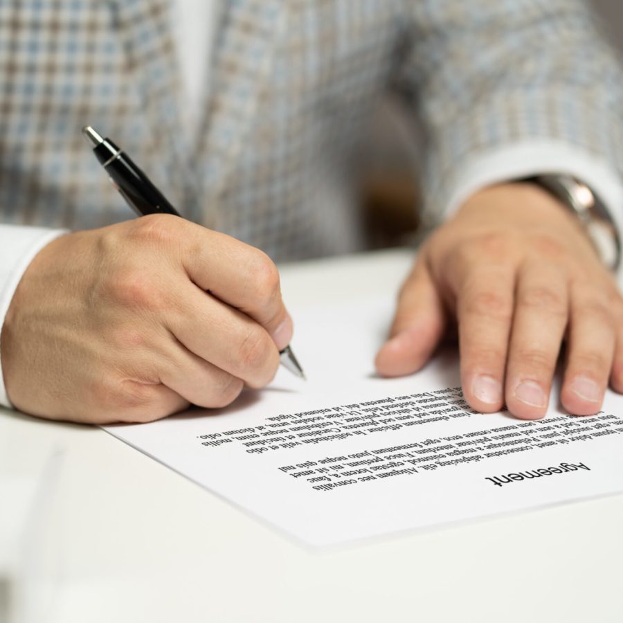 Seriös aussehende Hände schreiben mit einem Stift auf Papier