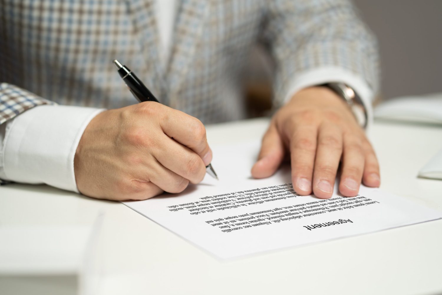 Seriös aussehende Hände schreiben mit einem Stift auf Papier